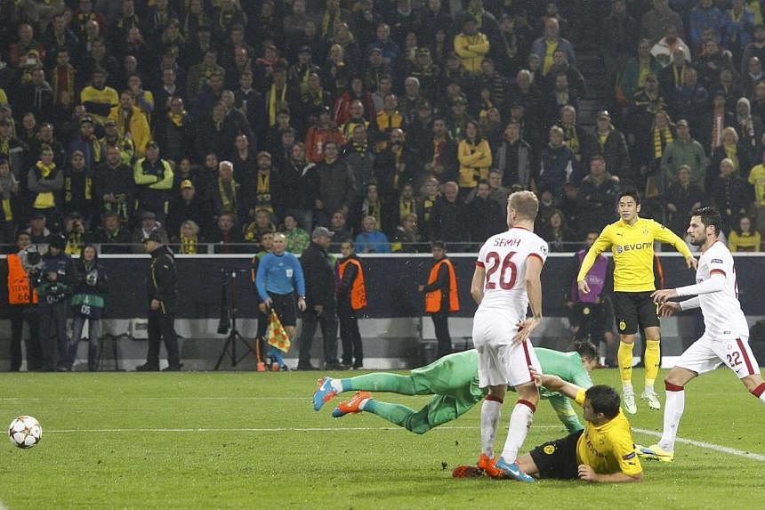 Borussia Dortmund's Sokratis Papastathopoulos (centre) scores a goal against Galatasaray's gaolkeeper Fernando Muslera during their Champions League group D soccer match in Dortmund on Nov 4, 2014. -- PHOTO: REUTERS