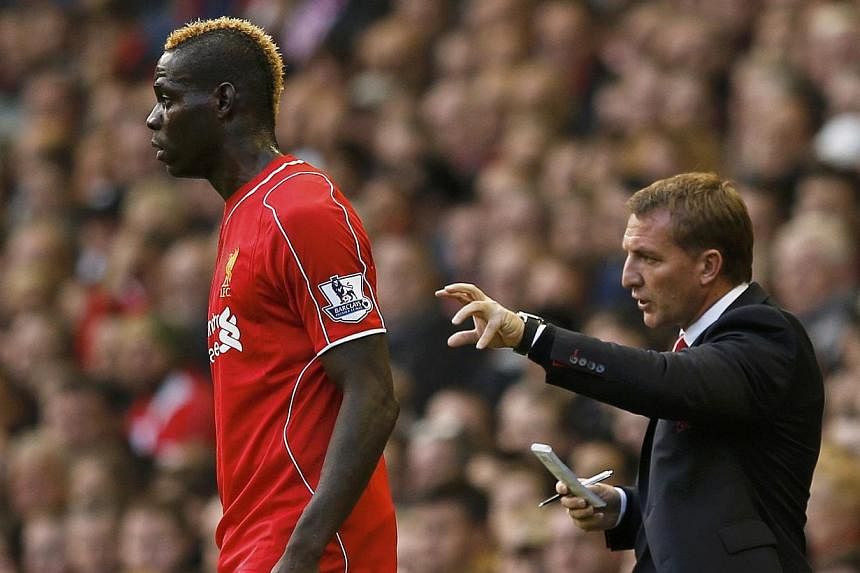 Liverpool's Mario Balotelli watches play as manager Brendan Rodgers gives instructions during their English Premier League soccer match against Hull City at Anfield in Liverpool, northern England, on Oct 25, 2014. Rodgers dropped a host of first-team