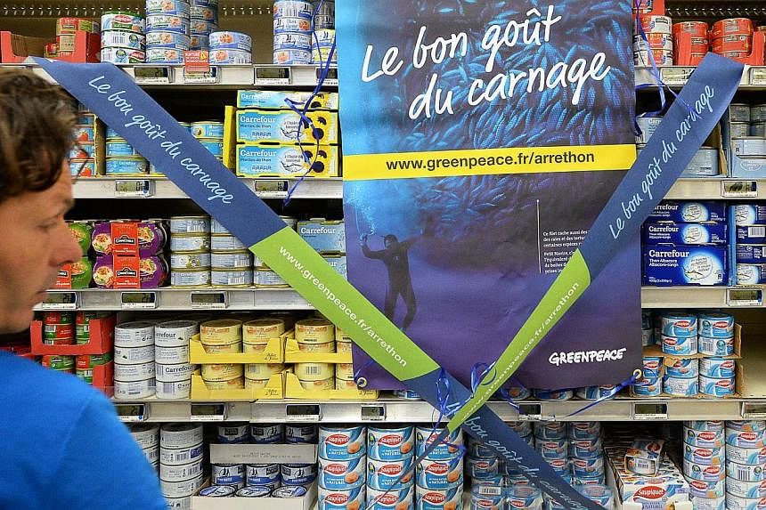 A Greenpeace campaign to denounce fishing conditions for tuna at a supermarket in Marseille, southern France, on Oct 25, 2014.The&nbsp;banner reads "The good taste of carnage". The environmental group&nbsp;launched a campaign on Tuesday against 20 Eu