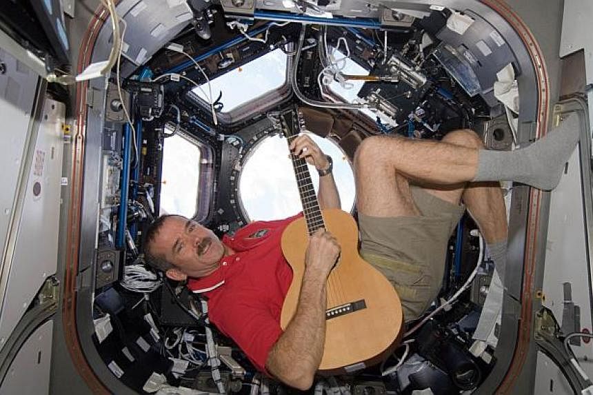 A Dec 25, 2012 Nasa photo shows Canadian Space Agency astronaut Chris Hadfield strumming his guitar in the International Space Station's Cupola. Hadfield, made famous by singing the song Space Oddity by David Bowie from the ISS, won the right to post