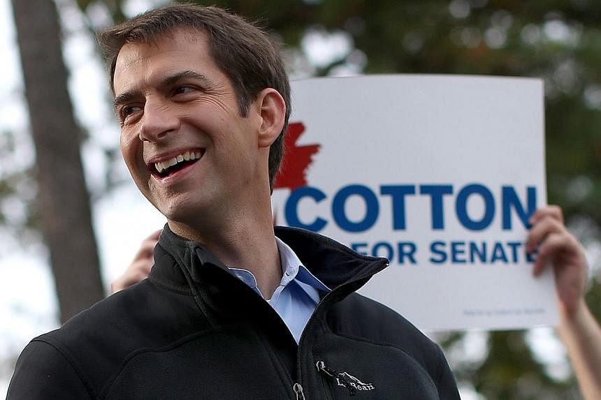 US Republican Tom Cotton and republican candidate for US Senate in Arkansas waits to greet people entering a polling place in Little Rock, Arkansas on Nov 4, 2014. -- PHOTO: AFP&nbsp;