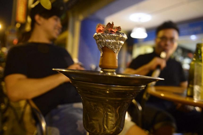 A customer smoking a shisha or "hookah" pipe at a cafe on Bussorah Street on Nov 4, 2014. -- ST PHOTO: MARK CHEONG