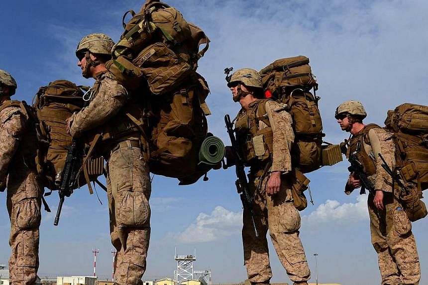 US Marines board a transport aircraft headed to Kandahar as British and US forces withdraw from the Camp Bastion-Leatherneck complex at Lashkar Gah in Helmand province, Afghanistan, on Oct 27, 2014. -- PHOTO: AFP