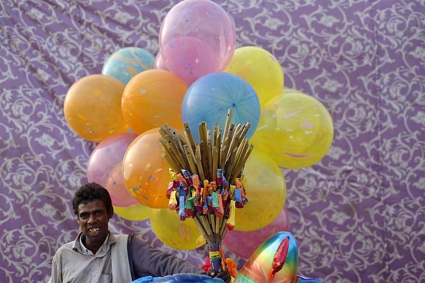 A vendor selling balloons waits for customers on the banks of the river Yamuna during the Hindu religious festival of Chatt Puja in New Delhi on Oct 29, 2014.&nbsp;Two foreign tourists on holiday in India unwittingly landed in jail this week after st