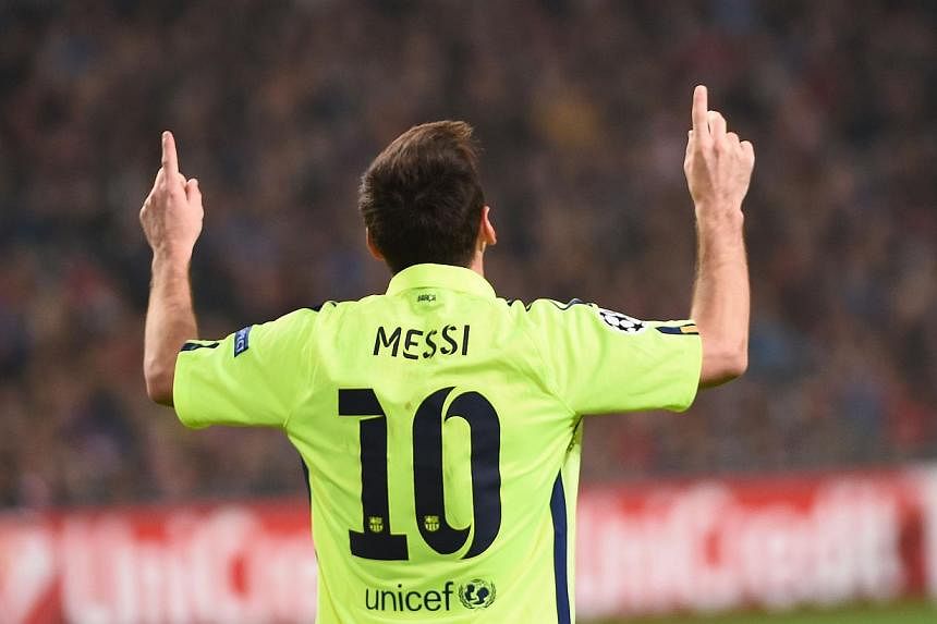 Barcelona's Argentinian forward Lionel Messi celebrates after scoring his second goal during the Champions League football match between Ajax Amsterdam and FC Barcelona in Amsterdam, on Nov 5, 2014. -- PHOTO: AFP