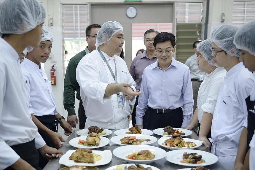 Education Minister Heng Swee Keat being briefed by chef Nicholas Ng, a culinary teacher at Assumption Pathway, during his visit to the specialised secondary school yesterday. Mr Heng announced new work-study programmes for graduates of Northlight and