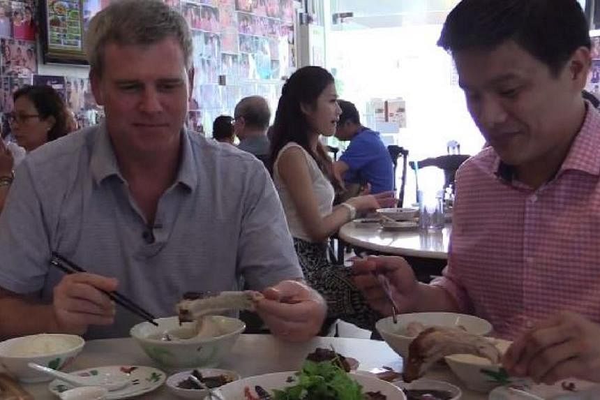 US ambassador Kirk Wagar (left) trying out bak kut teh at Rangoon restaurant Founder. -- PHOTO: FACEBOOK/U.S. EMBASSY SINGAPORE