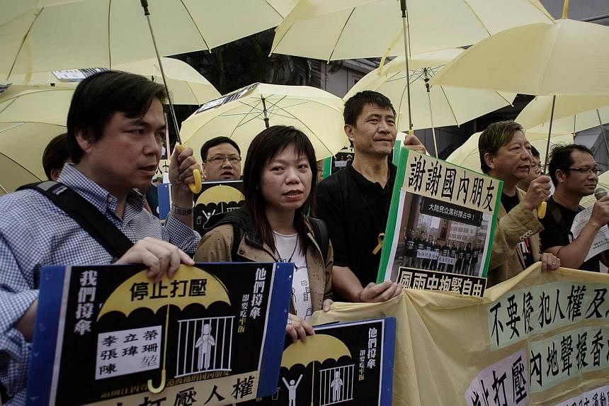 Protesters holding yellow umbrellas march towards the China liaison office in Hong Kong demanding the release of people arrested in mainland China for their support of the Hong Kong pro-democracy movement on Nov 5, 2014. -- PHOTO: AFP