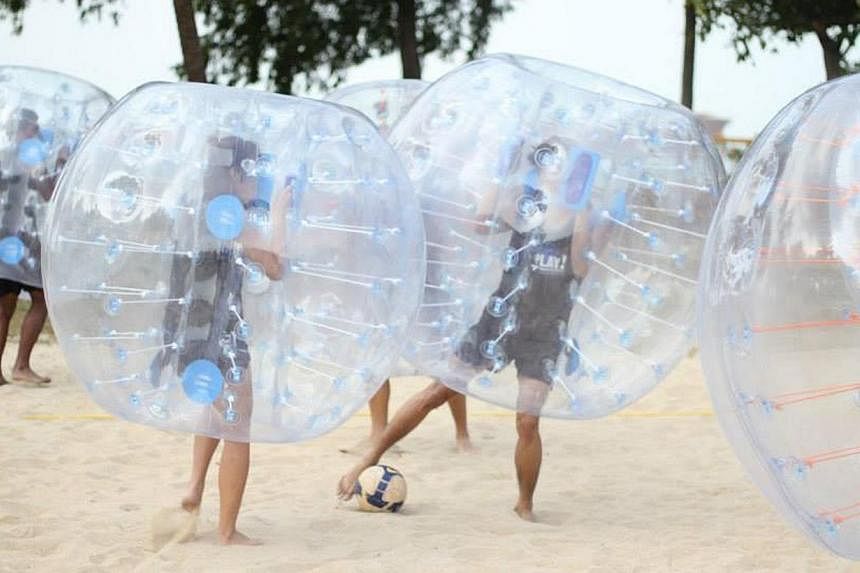Participants cocooned within giant bubbles bump, shove and crash into one another during a game. -- PHOTO:&nbsp;VAKK SINGAPORE