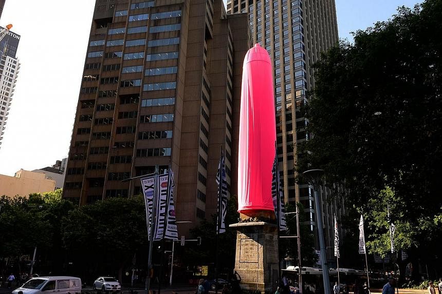 A gaint gaint condom is seen over a heritage-listed obelisk at Hyde Park in Sydney on Nov 7, 2014.&nbsp;An 18-metre bright pink condom raised eyebrows in Sydney on Friday after it was erected over a Sydney landmark as part of a new awareness campaign