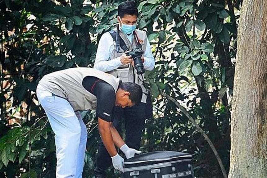 Penang Hospital forensic personnel closing the luggage bag with the body part inside to bring it to the hospital for a post-morterm.&nbsp;A pair of mutilated legs believed to be that of a murdered foreigner was found on Friday at the Pulau Burung dum