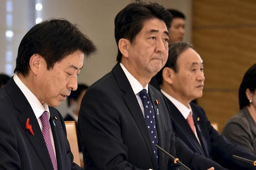 Japan's Prime Minister Shinzo Abe (second from left), flanked by Labour, Health and Welfare Minister Yasuhisa Shiozaki (left), Chief Cabinet Secretary Yoshihide Suga (second from right) and Internal Affairs and Communications Minister Sanae Takaichi 