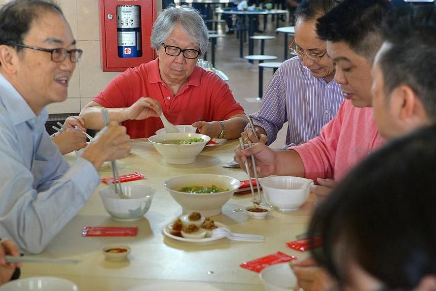 Professor Tommy Koh (centre, in red shirt) tries out the fish soup at from Ng Seng Heng at Pek Gio Market with the rest of the judges, as part of the annual Singapore Hawker Masters awards, which began on Friday, Nov 7. -- ST PHOTO: NG SOR LUAN