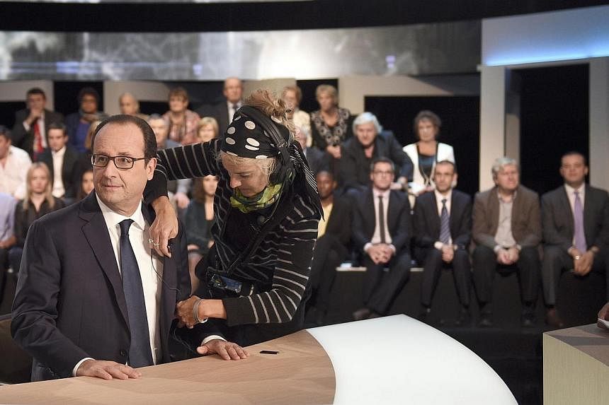 French President Francois Hollande arrives on stage before appearing on a TF1 television prime time news live broadcast at their studios in Aubervilliers, near Paris, Nov 6, 2014. Hollande, the most unpopular French president in history, admitted on 