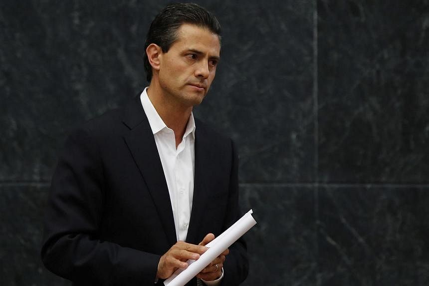 Mexico's President Enrique Pena Nieto looks on after addressing the media about a private meeting with the relatives of 43 missing students on Oct 29, 2014.&nbsp;Pena Nieto has shortened an upcoming trip to major summits in China and Australia amid a