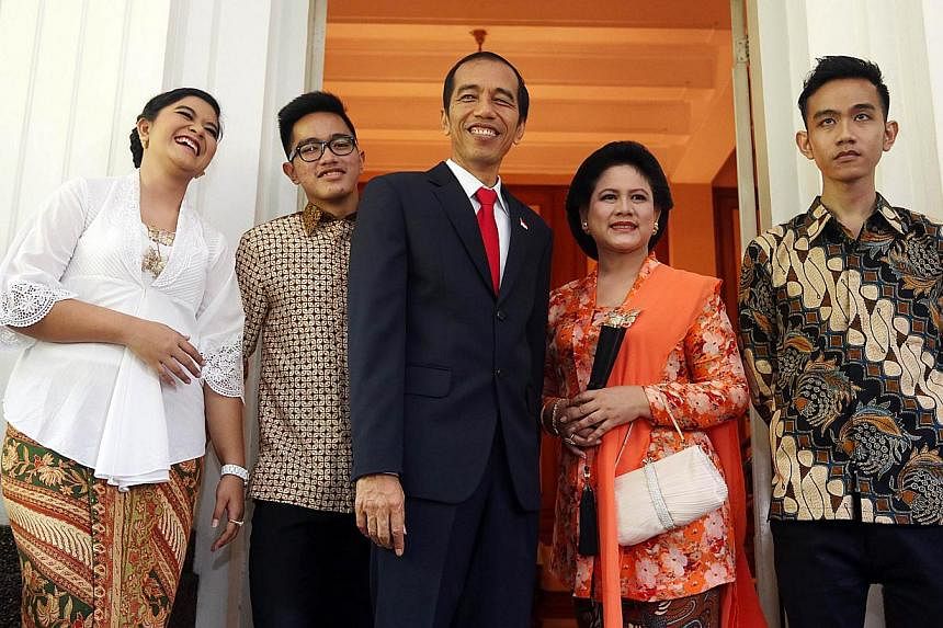 Indonesia's President Joko Widodo (centre) stands with First Lady Iriana Widodo (fourth left), son Gibran Rakabuming (fifth left), daughter Kahiyang Ayu (left) and Kaesang Pangarep (second left) for an unofficial portrait of Indonesia's First Family 
