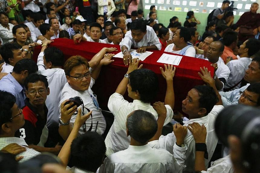 Supporters and relatives surround the coffin of slain journalist Par Gyi during his funeral ceremony at Yaway cemetery in Yangon, Nov 7, 2014.&nbsp;&nbsp;Myanmar authorities exhumed the body on Wednesday of a journalist killed in military custody, an