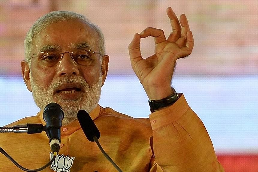 India Prime Minister Narendra Modi beefed up his government on Sunday, appointing 21 new ministers in a bid to speed up promised economic reforms after storming to power five months ago. -- PHOTO: AFP