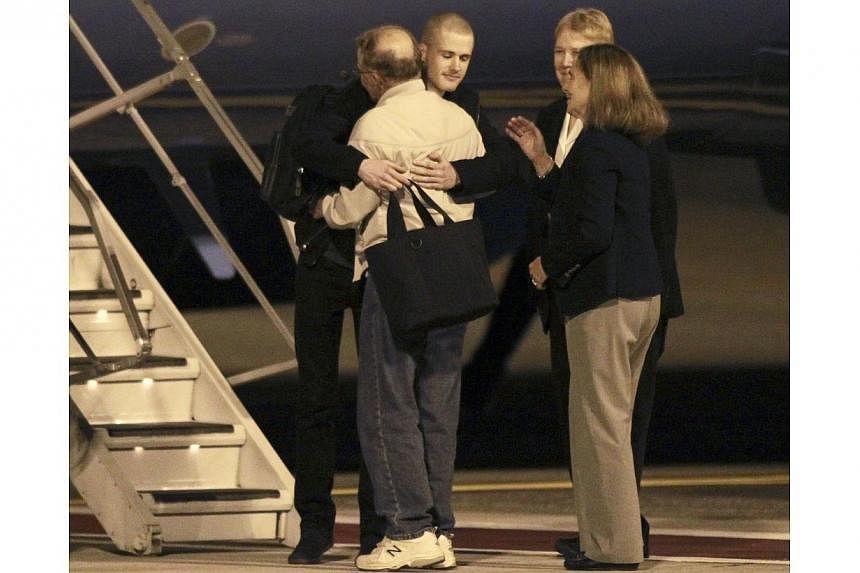 Matthew Todd Miller (centre, facing camera) reunites with his family members after he and Kenneth Bae (not pictured) landed aboard a US Air Force jet at McChord Field at Joint Base Lewis-McChord, Washington on Nov 8, 2014. -- PHOTO: REUTERS
