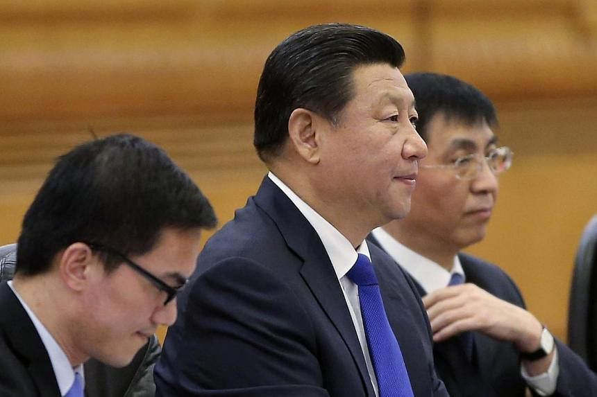 China's President Xi Jinping (centre) on Sunday reminded a senior Taiwanese envoy of Beijing's opposition to independence for the island, state media reported, after several recent disputes which have overshadowed improved ties. -- PHOTO: REUTERS