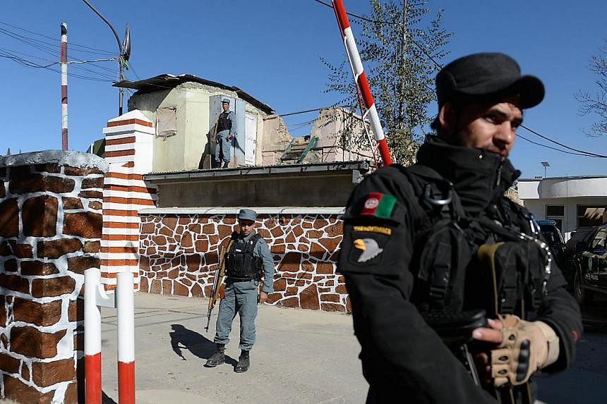 Afghan policemen stand guard at the entrance to police headquarters in Kabul on Nov 9, 2014.&nbsp;-- PHOTO: AFP