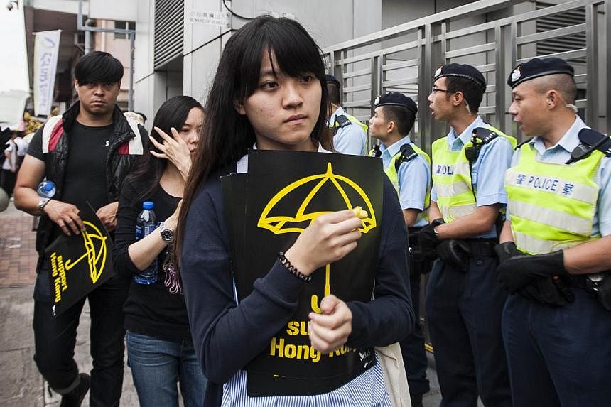 A pro-demcracy protester holds a yellow umbrella sign during a rally to the Liaison Government Office in Hong Kong on Nov 9, 2014. -- PHOTO: AFP