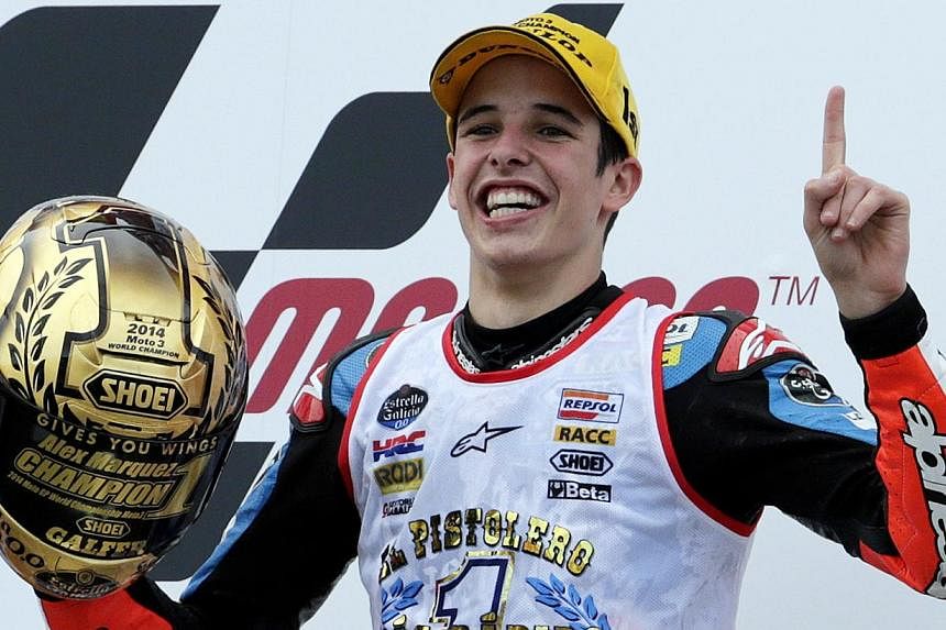 Honda Moto3 rider Alex Marquez of Spain celebrates winning the world championship on the podium after he placed third at the Valencia Motorcycle Grand Prix at the Ricardo Tormo racetrack in Cheste, near Valencia, on Nov 9, 2014.&nbsp;Marquez made mot