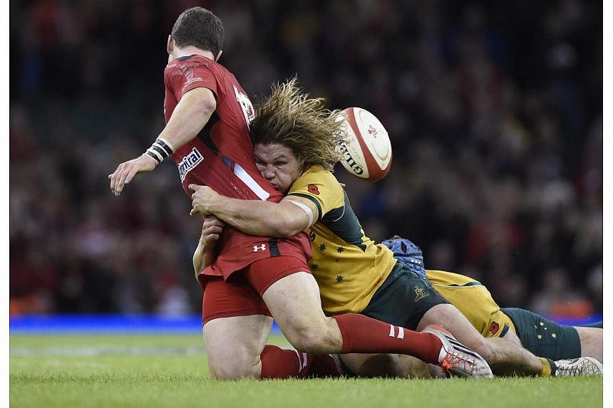 Wales' George North is tackled by Australia's Michael Hooper (right) during their Autumn International rugby union match at the Millennium Stadium in Cardiff, Wales, Nov 8, 2014. Australia edged Wales 33-28 to extend Wales' losing streak to southern 