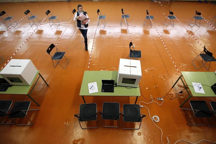 A volunteer makes preparations at a polling place for the 9N consultation in Sant Feliu de Llobregat, near Barcelona, on Nov 8, 2014. -- PHOTO: REUTERS
