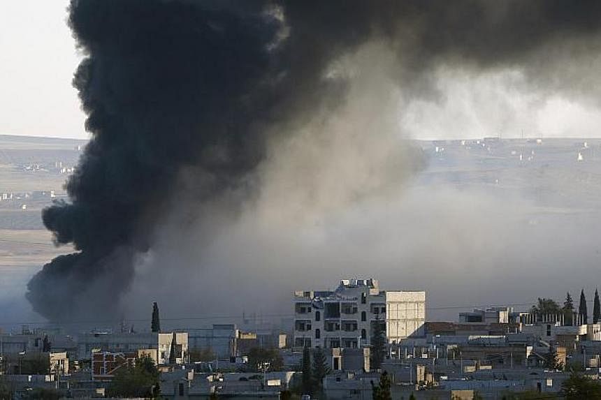 Thick black smoke rises over an eastern Kobane neighbourhood following an airstrike on Nov 8, 2014. Picture taken from the Turkish side of the Turkey-Syria border. US-led air strikes have targeted a gathering of Islamic State leaders in Iraq in a tow