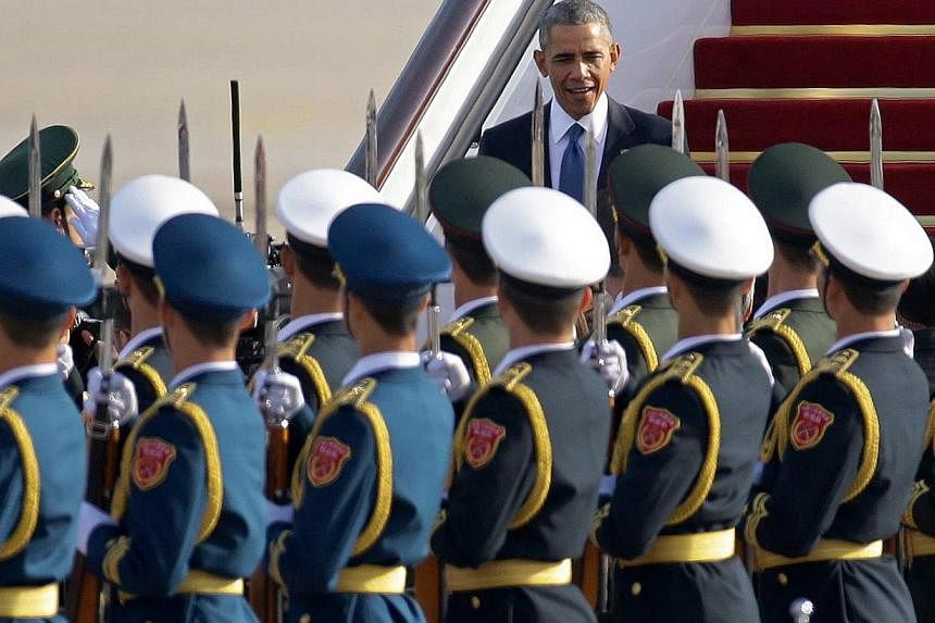 Honour guards saluting as US President Barack Obama steps from Air Force One upon his arrival in Beijing, on Nov 10, 2014. -- PHOTO: REUTERS