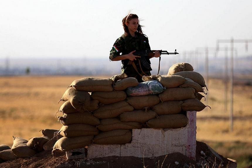 An Iranian Kurdish female member of the Freedom Party of Kurdistan (PAK) keeps a position in Dibis, some 50 kms northwest of Kirkuk, on Sept 15, 2014.&nbsp;Iran said on Monday that it was at Iraq's disposal to help its neighbour battle the Islamic St