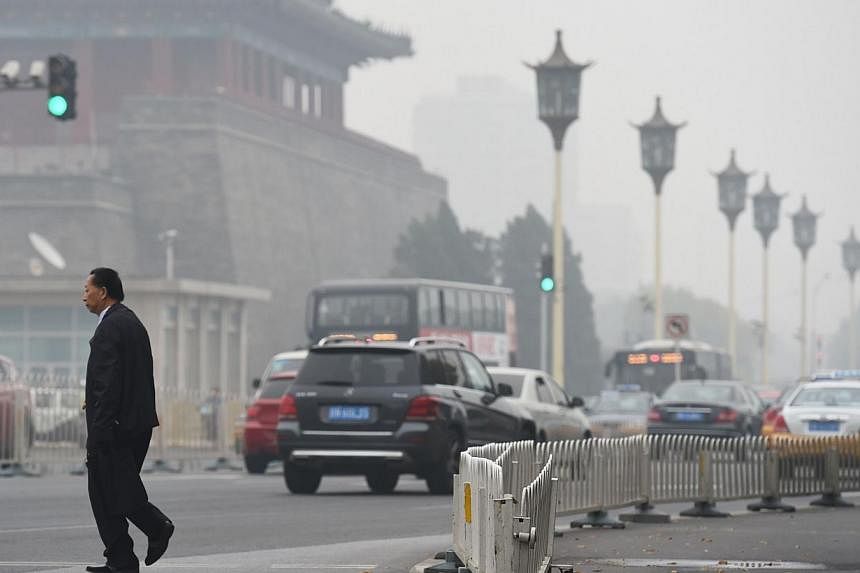 A man crosses a road on a polluted day in Beijing on Oct 20, 2014.&nbsp;Chinese President Xi Jinping has been checking Beijing's pollution first thing every morning, he told world leaders Monday, after authorities pulled out all the stops to avoid th