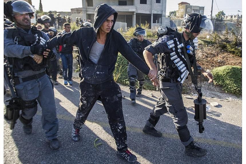 Israeli security forces detain an Arab-Israeli youth during clashes in the town of Kfar Kana, in northern Israel on Nov 9, 2014, a day after security forces shot dead a 22-year-old Arab-Israeli man.&nbsp;A Palestinian stabbed and critically wounded a