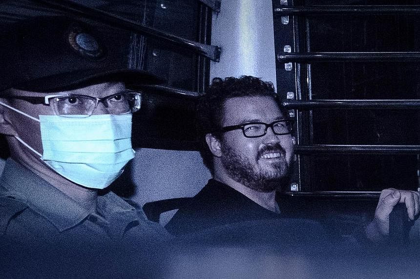 British banker Rurik Jutting, charged with the grisly murders of two women, smiles as he sits in a prison van leaving the eastern court in Hong Kong on Nov 10, 2014.&nbsp;Jutting's case was adjourned on Monday so that he could undergo psychiatric eva