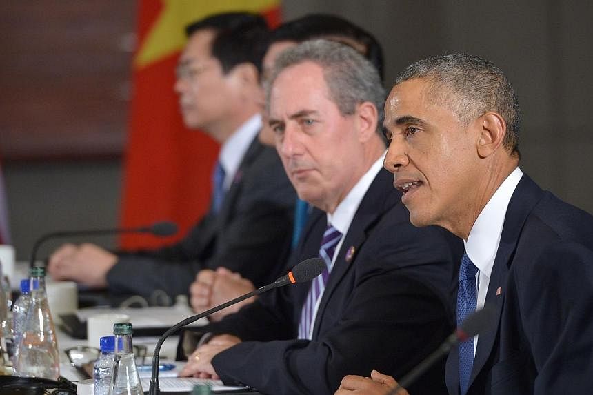 US President Barack Obama (right) speaks during a meeting with leaders from the Trans-Pacific Partnership at the US Embassy in Beijing on Nov 10, 2014, in Beijing. Mr&nbsp;Obama said on Monday that he sees momentum building for a Washington-backed fr