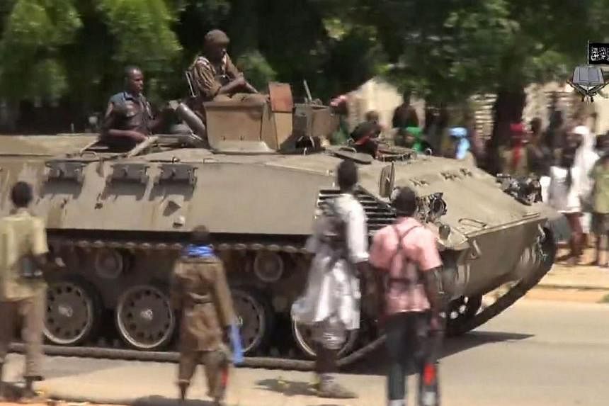 A screengrab taken on Nov 9, 2014, from a new Boko Haram video released by the Nigerian Islamist extremist group shows Boko Haram fighters parading on a tank in an unidentified town.&nbsp;A suicide bomb attack killed 47 students and injured 79 others
