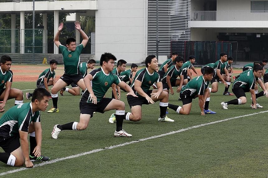 The visiting Maori All Blacks rugby team take around 100 youngsters through their paces during a coaching session at Raffles Institution. -- ST PHOTO: LAU FOOK KONG