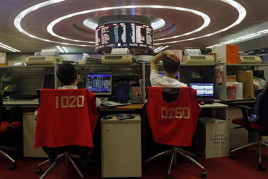 Floor traders monitor share prices during afternoon trading at the Hong Kong Stock Exchange in Hong Kong on Oct 28, 2014. -- PHOTO: REUTERS
