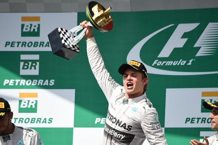 Mercedes AMG Petronas German driver Nico Rosberg (centre), flanked by teammate Lewis Hamilton (left) and Ferrari's Felipe Massa (right), celebrates on the podium after winning the Brazilian Formula One Grand Prix at the Interlagos racetrack in Sao Pa