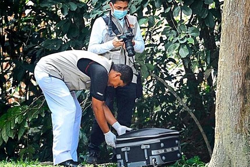 Penang Hospital forensic personnel taking the bag with a women's body inside to the hospital. -- PHOTO: THE STAR / ASIA NEWS NETWORK