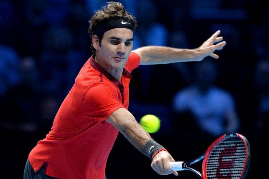 Switzerland's Rodger Federer returns to Canada's Milos Raonic during their singles group B match on the first day of the ATP World Tour Finals tennis tournament in London on Nov 9, 2014. -- PHOTO: AFP