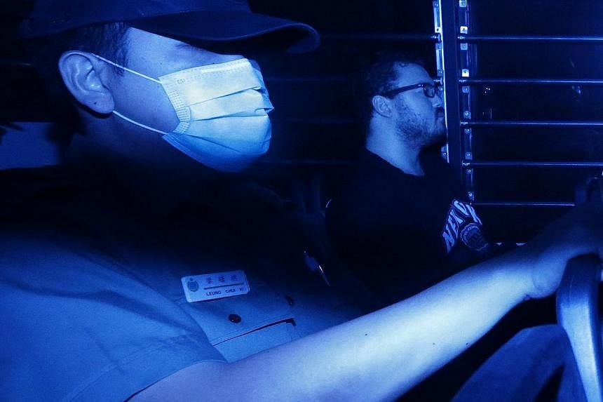 Rurik George Caton Jutting (right), a British banker charged with two counts of murder, sitting in a prison bus as he arrives at the Eastern Law Court in Hong Kong. -- PHOTO: REUTERS