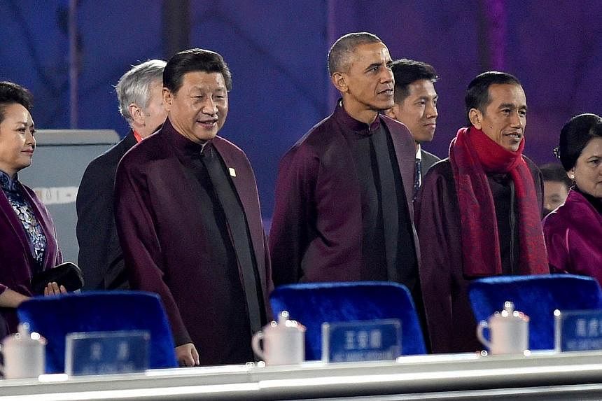 Chinese President Xi Jinping (second left) and US President Barack Obama (centre) prepare to watch the fireworks show during the Asia-Pacific Economic Cooperation (APEC) summit in Beijing on Nov 10, 2104. -- PHOTO: AFP