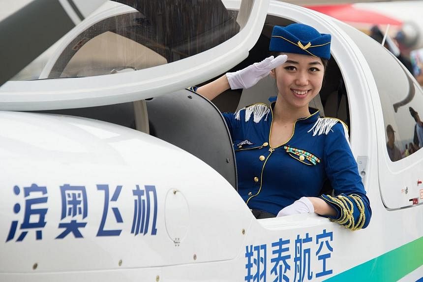 A model poses in a Binao Diamond light aircraft at the Airshow China 2014 in Zhuhai, south China's Guangdong province on Nov 11, 2014.&nbsp;Global aviation firms flocked to China on Tuesday to show off their wares as economic development and an expan