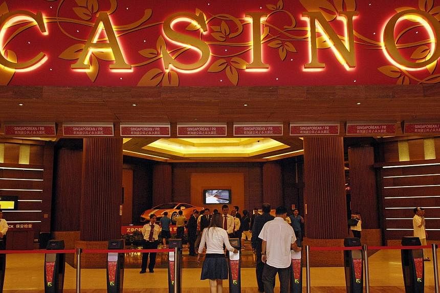 Visitors enter the casino at Genting Singapore's Resorts World Sentosa, in Singapore, May 12, 2010. -- PHOTO: BLOOMBERG