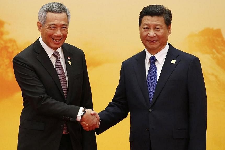 Singapore's Prime Minister Lee Hsien Loong (left) shakes hands with China's President Xi Jinping during a welcoming ceremony for the Asia-Pacific Economic Cooperation (APEC) summit, inside the International Convention Center at Yanqi Lake in Beijing 