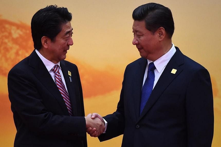 Japan's Prime Minister Shinzo Abe (left) shakes hands with China's President Xi Jinping as he arrives for the Asia-Pacific Economic Cooperation (Apec) leaders meeting at Yanqi Lake, north of Beijing on Nov 11, 2014.&nbsp;China and Japan "need each ot