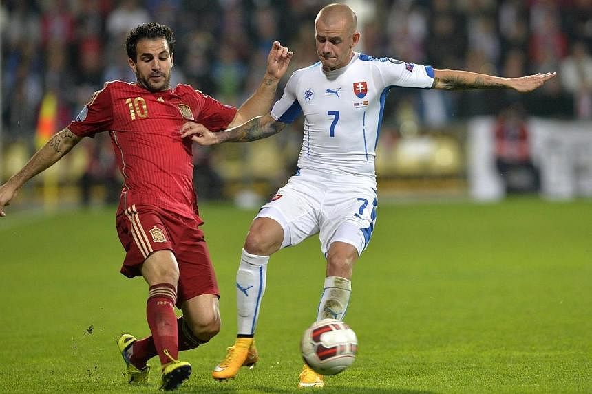 Spain's midfielder Cesc Fabregas (left) vies for the ball with Vladimir Weiss of Slovakia during the Euro 2016 qualifing football match between Slovakia and Spain in Zilina on Oct 9, 2014.&nbsp;Fabregas is out of Spain' Euro 2016 qualifier at home to
