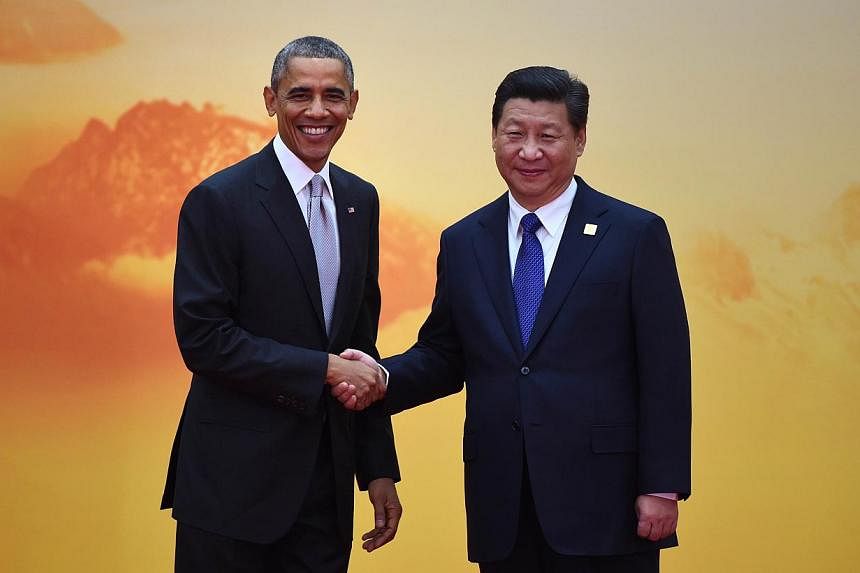 US President Barack Obama (left) shakes hands with China's President Xi Jinping as he arrives for the Asia-Pacific Economic Cooperation (Apec) leaders meeting at Yanqi Lake, north of Beijing on Nov 11, 2014. -- PHOTO: AFP